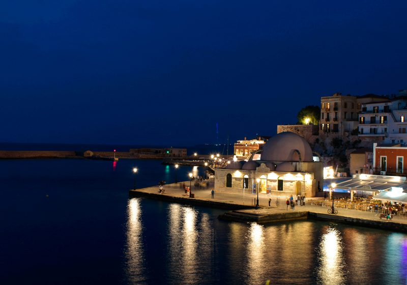Casa Delfino — Chania old harbor at dusk with illuminated Kioutsouk Hasan Mosque